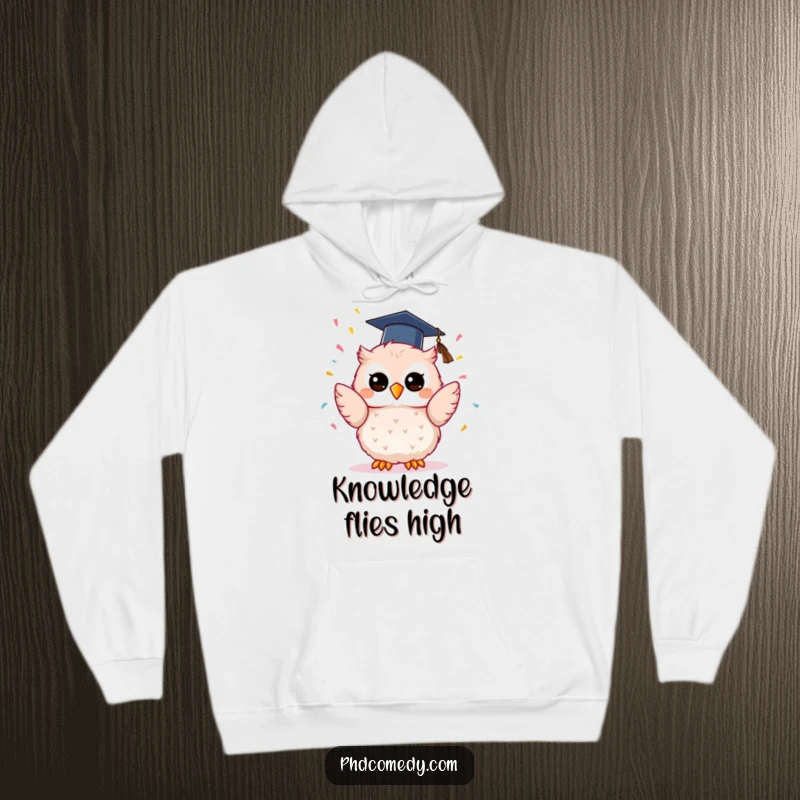 Funny kawaii owl in a graduation cap, ecstatically tossing confetti upwards, featured on a cozy hoodie.